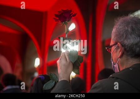 A person holds a rose in the middle of the funeral of Luisa Toledo