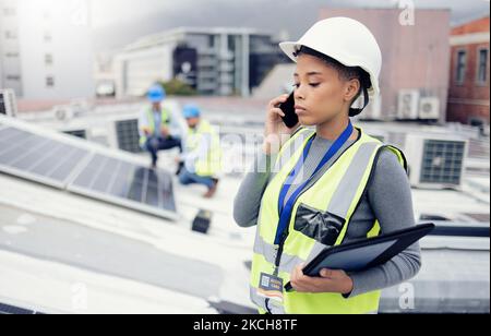 Engineer woman talking with phone, solar energy on roof and sustainable renewable energy in construction. Building manager, working with eco friendly Stock Photo
