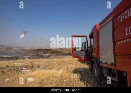 A Sikorsky S-64E Skycrane, registered N173AC and operated by Erickson Inc. - Erickson Air Crane, firefighting helicopter drops water over the fire on the hills with bushes and illegally dump garbage place near the industrial area of Thessaloniki and the residential area near settlement of Diavata and the village of Neochorodouda in Oreokastro and Delta Municipality assisting the ground force to extinguish the bushfire. Greece is having many fires, wild fires, forest firest etc as the country is facing a continuous heatwave and arid season with a month almost with no rain and high temperatures, Stock Photo