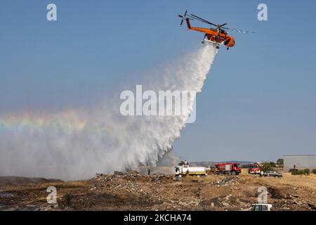 A Sikorsky S-64E Skycrane, registered N173AC and operated by Erickson Inc. - Erickson Air Crane, firefighting helicopter drops water over the fire on the hills with bushes and illegally dump garbage place near the industrial area of Thessaloniki and the residential area near settlement of Diavata and the village of Neochorodouda in Oreokastro and Delta Municipality assisting the ground force to extinguish the bushfire. Greece is having many fires, wild fires, forest firest etc as the country is facing a continuous heatwave and arid season with a month almost with no rain and high temperatures, Stock Photo