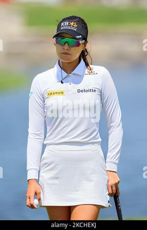In Gee Chun, of South Korea, putts with one shoe on the third green