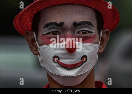 A clown from a group called 'Aku Badut Indonesia' or 'I am an Indonesian Clown' looks on during an awareness campaign calling for people to always wear their masks and get a vaccine to help curb the spread of coronavirus at a busy intersection in Depok, West Java on July 23, 2021. Indonesia, the world's fourth-most populous country, reported a record daily number of 1,566 Covid-19 deaths on Friday, taking total fatalities to 80,598. It also recorded 49,071 new coronavirus infections, bringing the total number of cases 3,082,410, making it the center of Asia's outbreak. (Photo by Afriadi Hikmal Stock Photo