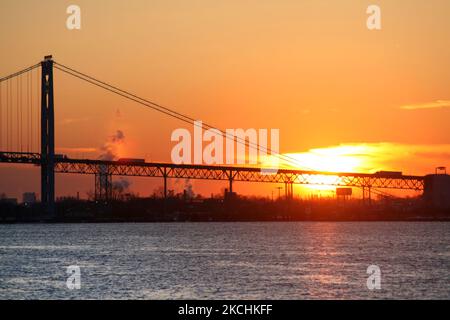 The sun sets behind the Ambassador Bridge over the Detroit River between Detroit, Michigan and Windsor, Ontario, Canada. Windsor-Detroit is the busiest border crossing, with more than 7,000 trucks crossing daily on average. (Photo by Creative Touch Imaging Ltd./NurPhoto) Stock Photo