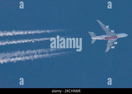 Emirates Airbus A380 aircraft as seen flying in the blue summer sky over Greece in Europe the route EK142 from Madrid MAD, Spain to Dubai DXB, UAE. The overflying wide-body double-decker long haul airplane has the registration A6-EVJ and is powered by 4x RR Trent 972 jet engines. Emirates relaunched flights with the A388 after the fleet was grounded due to the Coronavirus travel restrictions. The overfly airliner creates contrail or chemtrail while cruising at 41.000 feet, forming a white line of condensation trail in the atmosphere behind it. Emirates EK is the flag carrier of Dubai - United  Stock Photo