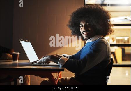 Its business, but my way. Cropped portrait of a handsome young male designer using his laptop while working late in the office. Stock Photo