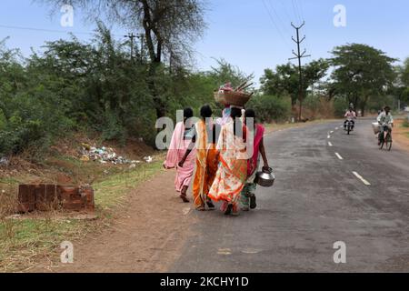 Group of Indian women carry baskets with tools on their heads as they walk along the roadside in Chandrapur, Maharashtra, India, on June 18, 2010. (Photo by Creative Touch Imaging Ltd./NurPhoto) Stock Photo