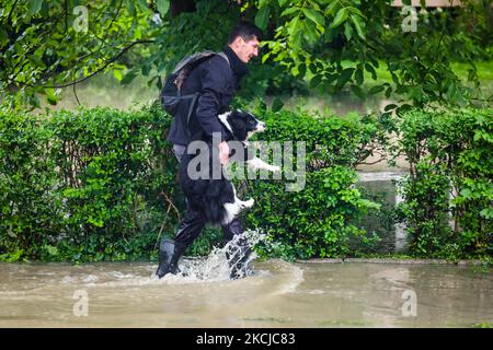 A man carries his dog after streets and households areas of Bierzanow district were flooded with heavy rain shower in Krakow, Poland on August 6th, 2021. (Photo by Beata Zawrzel/NurPhoto) Stock Photo