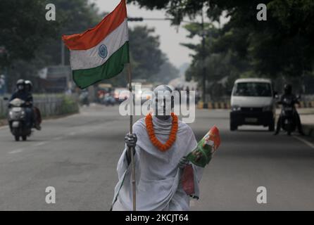 A man dressed as like as father of nation mahatma Gandhi as he is seen on the road and returns back home after attaining the 75th Independence Day celebration event in the eastern Indian state Odisha's capital city Bhubaneswar on August, 15, 2021. (Photo by STR/NurPhoto) Stock Photo