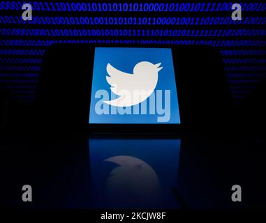 Twitter logo displayed on a phone screen is seen with binary code displayed on a laptop screen in this illustration photo taken in Krakow, Poland on August 17, 2021. (Photo by Jakub Porzycki/NurPhoto) Stock Photo