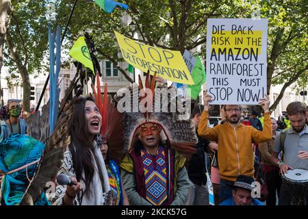 LONDON, UNITED KINGDOM - AUGUST 25, 2021: Activists and campaigners joined by indigenous people from Brazil protest near Brazilian Embassy in solidarity with the Indigenous peoples of Brazil as the Bolsonaro's government attempts to further open up Indigenous lands to mining and other commercial activities that could exacerbate the destruction of the Amazon rainforest on 25 August 2021 in London, England. The protesters demonstrate against Congressional bill 490/2007, which would prevent Indigenous peoples from obtaining legal recognition of their traditional lands if they were not present the Stock Photo