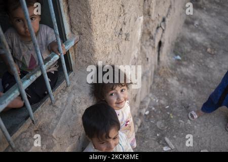 Unidentified Afghan refugee children who have escaped from their hometown city of Herat with their parents to Iran about three months ago while they feared the Taliban possible victory over the Afghan Government, look on as they stand just out of their home in an area in the south of Tehran, August 27, 2021. The Taliban seized power in Afghanistan on August 15, 2021, twenty years after the U.S. and International Coalition Forces have been attacked against the Osama bin Laden, who was a founder of al-Qaeda. (Photo by Morteza Nikoubazl/NurPhoto) Stock Photo