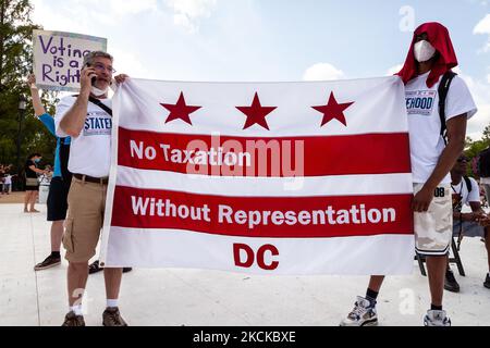 DC statehood activists display a Washington, DC, flag during the flagship event of a nationwide march for voting rights on the 58th anniversary of the March on Washington. Partcipating individuals and organizations demand an end to the filibuster and passage of the John Lewis Voting Rights Advancement Act and the For the People act to ensure federal protection of the right to vote. The event is sponsored by the Drum Major Institute, March On, SEIU, National Action Network, and Future Coalition, and has more than 225 partner organizations. (Photo by Allison Bailey/NurPhoto) Stock Photo