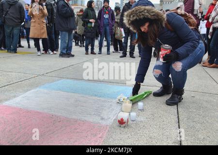 November 14, 2015, Toronto, Ontario, Canada --- Canadians place candles and flowers by a French flag during a vigil at Nathan Phillips Square in Toronto, Canada to show solidarity with the citizens of France a day after the Paris terrorist attacks. Islamic State jihadists claimed a series of coordinated attacks by gunmen and suicide bombers in Paris on November 13 that killed at least 129 people and injured more than 350 in scenes of carnage at a concert hall, restaurants and the national stadium. This attack is the deadliest attack in Paris since the Second World War. --- (Photo by Creative T Stock Photo