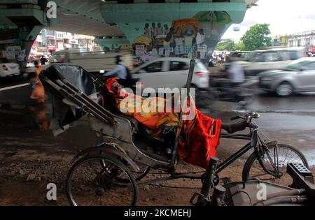 A rickshaw puller rests in his cycle rickshaw under an overpass bridge in the daily market area in the eastern Indian state Odisha's capital city Bhubaneswar. (Photo by STR/NurPhoto) Stock Photo