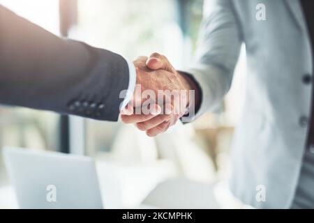 Well do great things together. two unrecognizable businessmen shaking hands after making a deal in the office. Stock Photo