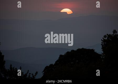 Sunset time with colorful sky and clouds. The sun sets behind the mountains over Volos city as seen from Pelion mountain between Portaria and Makrinitsa village. Portaria, Greece on September 17, 2021 (Photo by Nicolas Economou/NurPhoto) Stock Photo