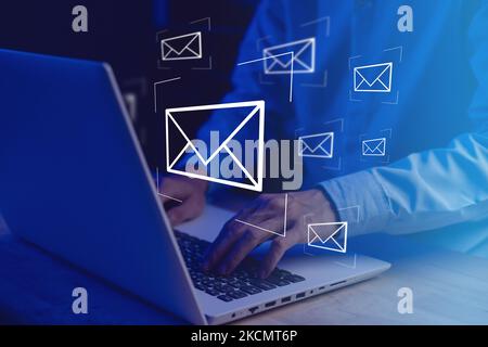 Businessman hands typing notebook (Laptop) with email icon and send e-mail or newsletter. Electronic mail marketing and online working internet networ Stock Photo