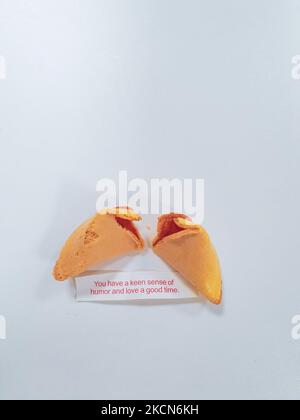 Broken fortune cookie with a positive vibe message under it and copy space around. Stock Photo