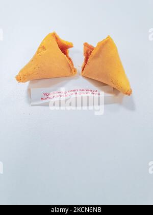 Broken fortune cookie with a positive vibe message under it and copy space around. Stock Photo