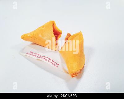 Broken fortune cookie with a positive vibe message under it and copy space around. Stock Photo