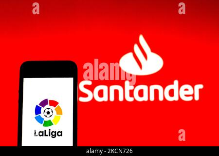 In this photo illustration a LaLiga logo seen displayed on a smartphone with a Banco Santander, S.A. logo in the background. (Photo by DAX Images/NurPhoto) Stock Photo
