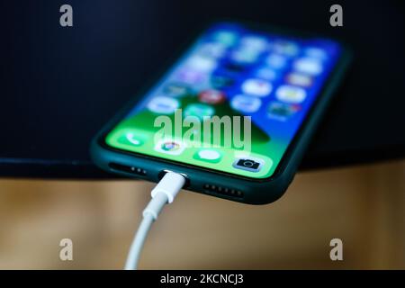 Apple iPhone connected to a Lightning cable is seen in this illustration photo taken in Poland on September 25, 2021. (Photo by Jakub Porzycki/NurPhoto) Stock Photo