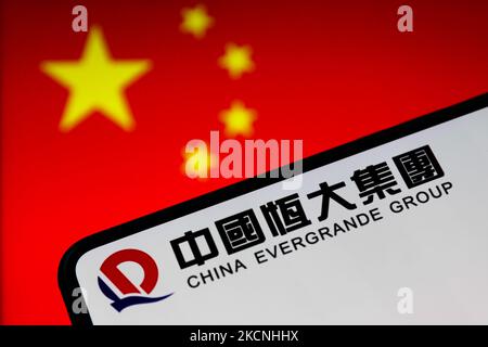 China Evergrande Group logo displayed on a phone screen and Chinese flag displayed in the background are seen in this illustration photo taken in Krakow, Poland on September 27, 2021. (Photo by Jakub Porzycki/NurPhoto) Stock Photo