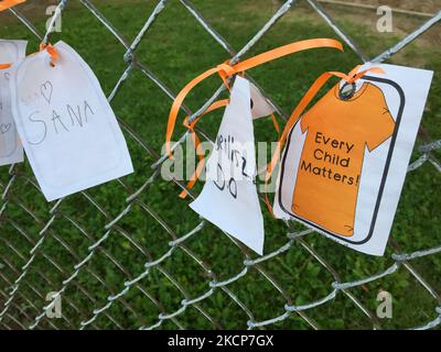 Small notes with the names of children and the words 'every child matters' tied with orange ribbons on the fence surrounding an primary school as Canadians marked the first annual National Day For Truth And Reconciliation in Toronto, Ontario, Canada, on 30 September 2021. Orange Shirt Day is an Indigenous grassroots commemorative day that honours the children who survived residential schools and remembers those who did not. National Day for Truth and Reconciliation honours the lost Aboriginal children and Survivors of residential schools, their families and communities. (Photo by Creative Touc Stock Photo