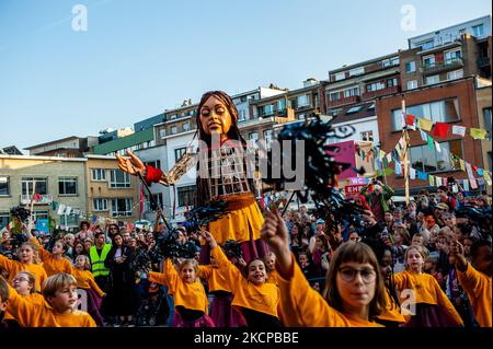 A giant puppet is currently grabbing attention across Europe to the plight of young refugees who have fled from Syria. Little Amal represents a nine-year-old Syrian refugee girl and is over 11-feet-tall. She has been walking nearly 8,000 km from the Syrian-Turkish border looking for her mother and it will end in November in Manchester. This weekend, Amal, which means “hope” in Arabic, was warmly welcomed by children, musicians, and other giants to the Borgerhout district known for its cultural diversity, on October 9th, 2021. (Photo by Romy Arroyo Fernandez/NurPhoto) Stock Photo