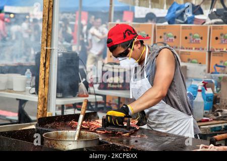 Chinese man grilling squid on a stick during an all-night Chinese market in Markham, Ontario, Canada. (Photo by Creative Touch Imaging Ltd./NurPhoto) Stock Photo