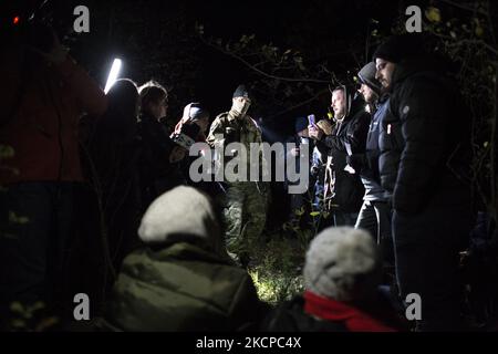 Group of illegal immigrants surrounded by journalists and border guard after crossing polish belarusian border near Michalowo on October 6, 2021. (Photo by Maciej Luczniewski/NurPhoto) Stock Photo