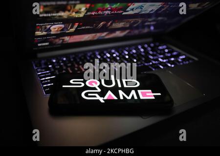 Squid Game series logo displayed on a phone screen and Netflix website displayed on a laptop screen are seen in this illustration photo taken in Krakow, Poland on October 13, 2021. (Photo by Jakub Porzycki/NurPhoto) Stock Photo