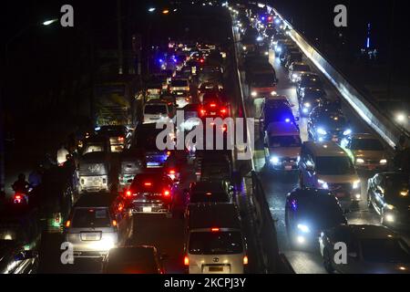 Commuters make their way through a traffic jam at night during Covid-19 Coronavirus pandemic in Dhaka, Bangladesh, on October 13, 2021.Last 10 years in Dhaka, average traffic speed has dropped from 21 km/hour to 7 km/hour, only slightly above the average walking speed. Congestion in Dhaka eats up 3.2 million working hours per day according to static reports. (Photo by Mamunur Rashid/NurPhoto) Stock Photo