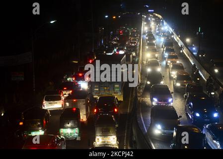 Commuters make their way through a traffic jam at night during Covid-19 Coronavirus pandemic in Dhaka, Bangladesh, on October 13, 2021.Last 10 years in Dhaka, average traffic speed has dropped from 21 km/hour to 7 km/hour, only slightly above the average walking speed. Congestion in Dhaka eats up 3.2 million working hours per day according to static reports. (Photo by Mamunur Rashid/NurPhoto) Stock Photo