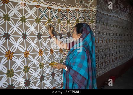 A resident paints alpine on a wall at Alpona village in chapainawabganj ...