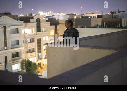 Abdolghani Jamshidi-60, An Afghan refugee who works as a construction worker, looks on while standing on a rooftop of a residential building that is currently under construction, after a working day in the Mehrshahr area in the west of the city of Karaj in Alborz province 53Km (33 Miles) northwestern Tehran on October 14, 2021. Abdolghani has left his motherland about six months ago for looking for a job in Iran to make money for his family and his children’s educational tuition but, He had to stay in Iran after the Taliban back to power in Afghanistan. (Photo by Morteza Nikoubazl/NurPhoto) Stock Photo