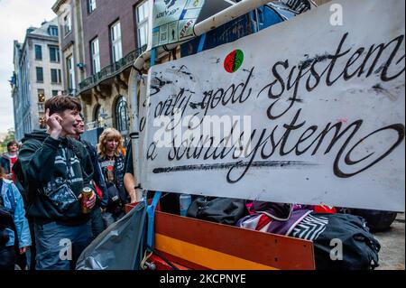 People are dancing behind one of the trucks during the colorful ADEV parade in Amsterdam. Every year, the ADEV demonstrators dance for creative free spaces in the city. This year, also they protest against the housing crisis, to demand to guarantee adequate and affordable housing for everyone. October 16th, 2021. (Photo by Romy Arroyo Fernandez/NurPhoto) Stock Photo