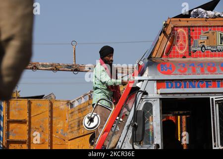 A Sikh driver cleans the windshield of his truck at Fruit mandi in Sopore, District Baramulla, Jammu and Kashmir, India on 20 October 2021. Traders at Fruit market sopore are worried after Non-Locals traders begin to leave the valley. Indian authorities have moved thousands of migrant workers in Kashmir to safer locations, while hundreds have fled the Kashmir valley after a wave of targeted killings. Most of the Labour and construction work in kashmir is done by the Non-Local Labourers, work at most of the construction is affected after the migrant workers left the Valley. Government estimates Stock Photo