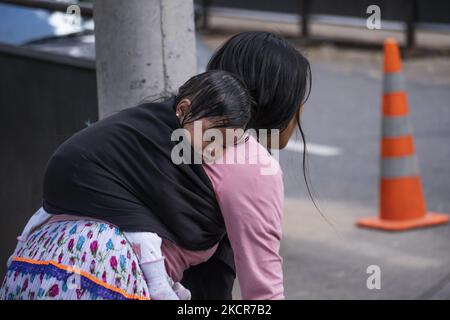 An indigenous woman carries her child in the national park on October 20, 2021 in Bogota, Colombia. Approximately 1,300 people have been camping in the national park for 20 days, waiting for the government to guarantee their return to their lands due to the violence in the country. (Photo by Daniel Garzon Herazo/NurPhoto) Stock Photo