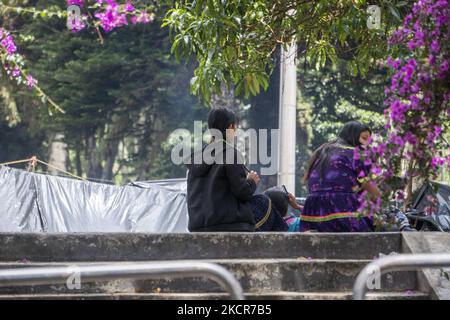 Two indigenous women sit in the national park on October 20, 2021 in Bogota, Colombia. Approximately 1,300 people have been camping in the national park for 20 days, waiting for the government to guarantee their return to their lands due to the violence in the country. (Photo by Daniel Garzon Herazo/NurPhoto) Stock Photo