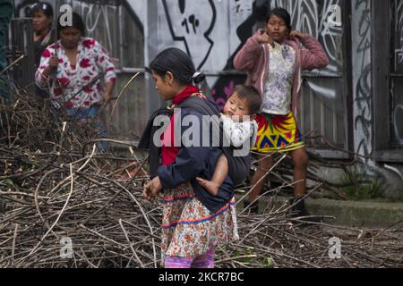 An indigenous woman carries her child in the national park on October 20, 2021 in Bogota, Colombia. Approximately 1,300 people have been camping in the national park for 20 days, waiting for the government to guarantee their return to their lands due to the violence in the country. (Photo by Daniel Garzon Herazo/NurPhoto) Stock Photo