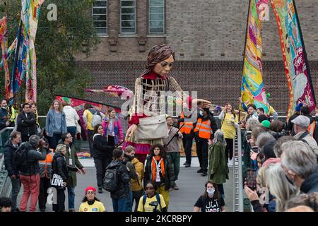 LONDON, UNITED KINGDOM - OCTOBER 23, 2021: Little Amal, a 3.5 metre-tall giant puppet representing a nine-year-old Syrian refugee child, interacts with members of the public outside Tate Modern on October 23, 2021 in London, England. Little Amal, designed by the Handspring Puppet Company, is part of 'The Walk' project by Britain’s Good Chance Theatre making a 8,000 km journey from Turkey to the United Kingdom to draw attention to the urgent needs of young refugees. (Photo by WIktor Szymanowicz/NurPhoto) Stock Photo