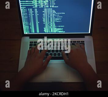 Disabling a network. an unrecognisable hacker using a laptop in the dark. Stock Photo