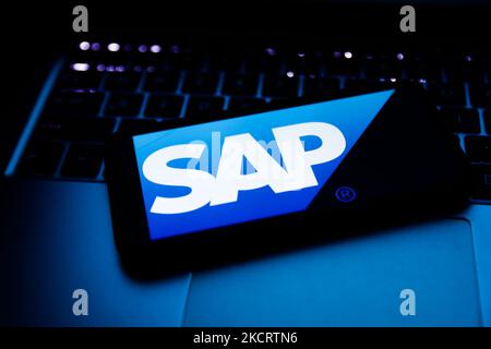 SAP logo displayed on a phone screen and a laptop keyboard are seen in this illustration photo taken in Krakow, Poland on October 30, 2021. (Photo by Jakub Porzycki/NurPhoto) Stock Photo