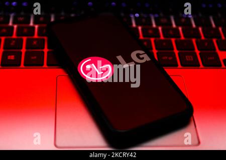LG logo displayed on a phone screen and a laptop keyboard are seen in this illustration photo taken in Krakow, Poland on October 30, 2021. (Photo by Jakub Porzycki/NurPhoto) Stock Photo