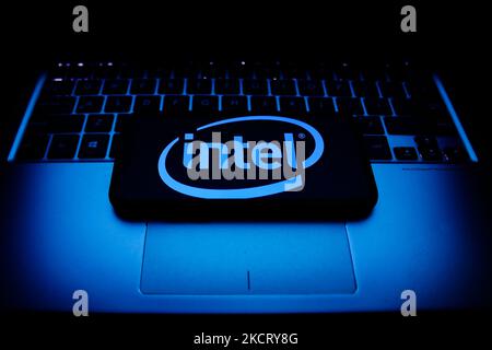 Intel logo displayed on a phone screen and a laptop keyboard are seen in this illustration photo taken in Krakow, Poland on October 30, 2021. (Photo by Jakub Porzycki/NurPhoto) Stock Photo