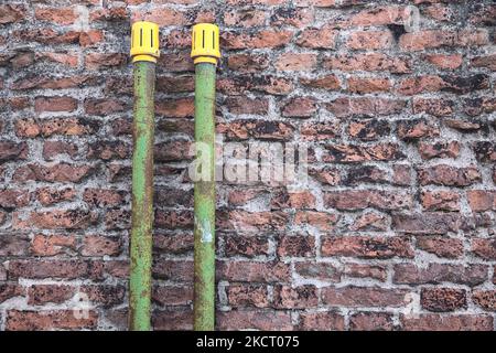 Green  pipes on a brick wall Stock Photo