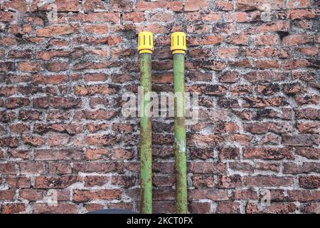 Green  pipes on a brick wall Stock Photo