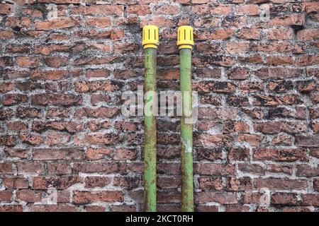 Green  pipes on a brick wall Stock Photo