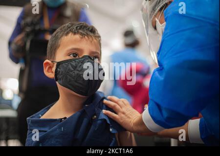 A child receives his first dose of the COVID-19 vaccine as the Colombian government begins to vaccinate children between ages 3 to 11 against the Coronavirus disease (COVID-19) with the China's SINOVAC vaccine, in Bogota, Colombia on October 31, 2021. (Photo by Sebastian Barros/NurPhoto) Stock Photo